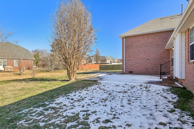 snowy yard with a patio area