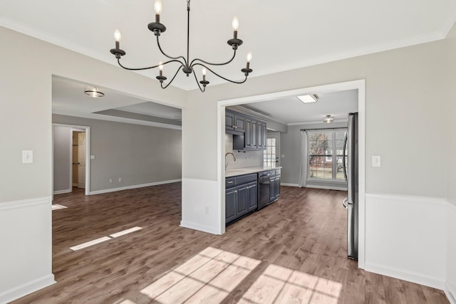 kitchen with decorative backsplash, stainless steel fridge, sink, and wood-type flooring