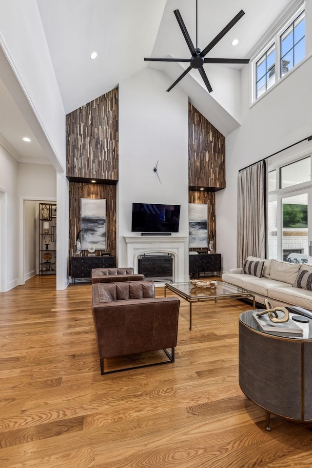 living room featuring high vaulted ceiling, light wood-type flooring, a wealth of natural light, and ceiling fan