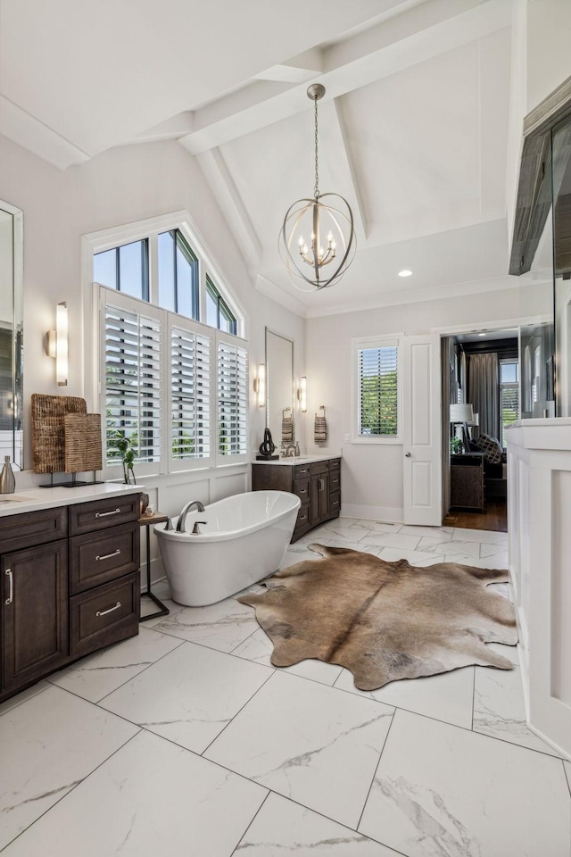 bathroom with a bath, an inviting chandelier, vaulted ceiling with beams, and vanity