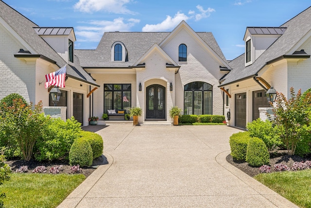 french country inspired facade featuring a garage