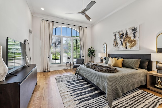 bedroom with light wood-type flooring, ceiling fan, and ornamental molding