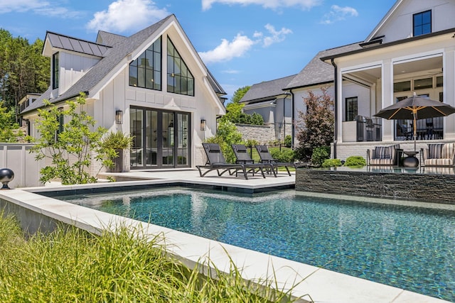 rear view of property featuring a patio area and a fenced in pool