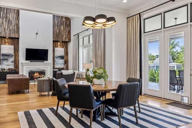 dining space featuring an inviting chandelier, ornamental molding, and light hardwood / wood-style flooring