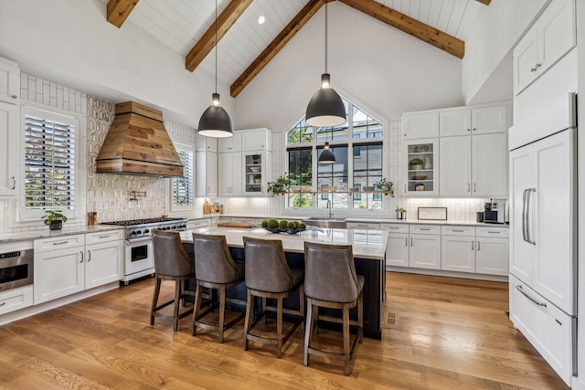 kitchen featuring backsplash, custom exhaust hood, hanging light fixtures, premium appliances, and white cabinets