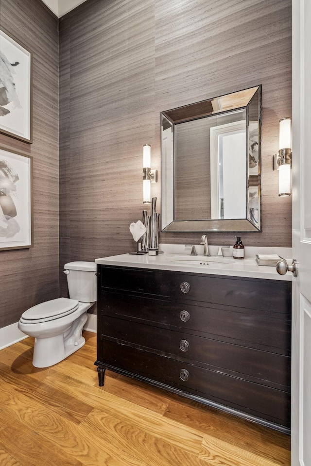 bathroom with wood-type flooring, toilet, and vanity