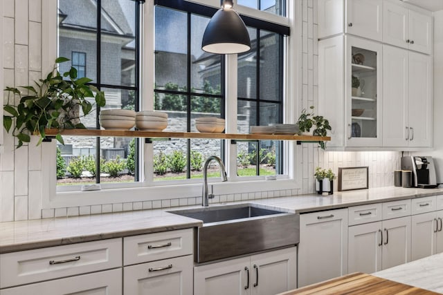 kitchen with plenty of natural light, white cabinets, and tasteful backsplash