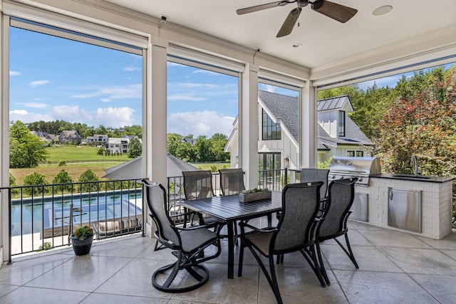 sunroom / solarium featuring ceiling fan and sink