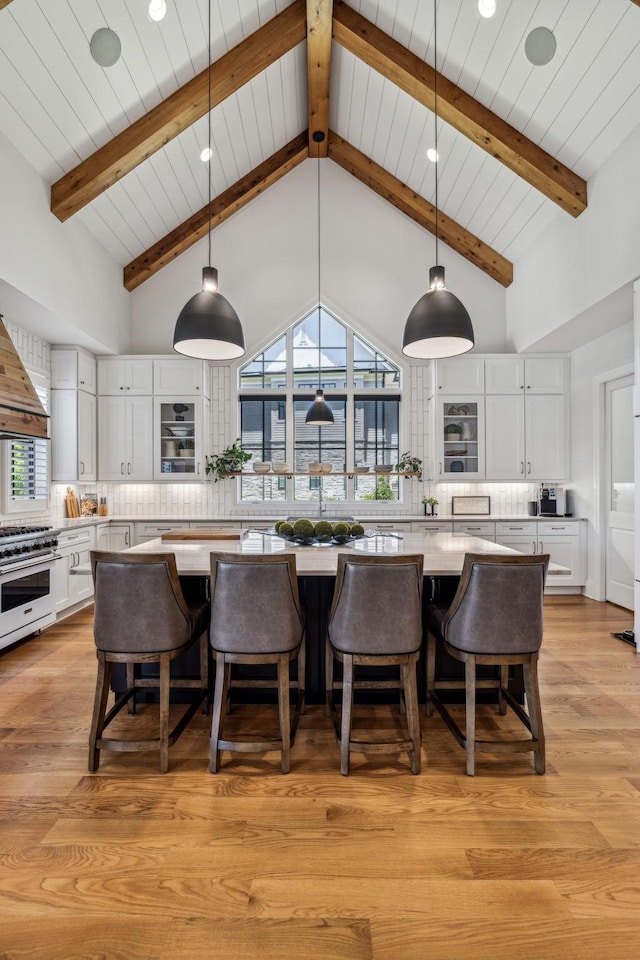 kitchen featuring decorative backsplash, light hardwood / wood-style floors, white cabinetry, and a large island