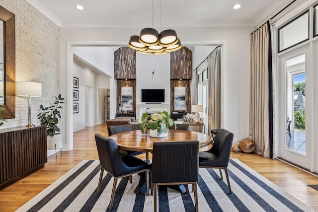 dining area featuring a chandelier, ornamental molding, and light hardwood / wood-style flooring