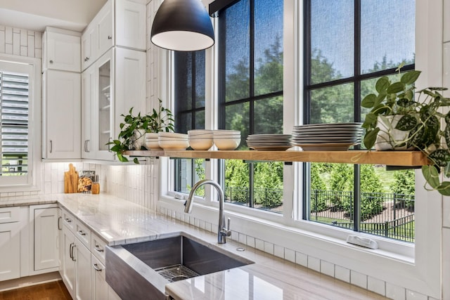 kitchen with white cabinets, decorative backsplash, sink, dark hardwood / wood-style floors, and light stone counters