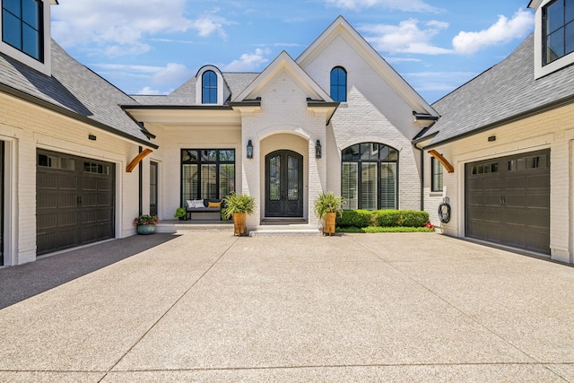 french country style house featuring covered porch and a garage