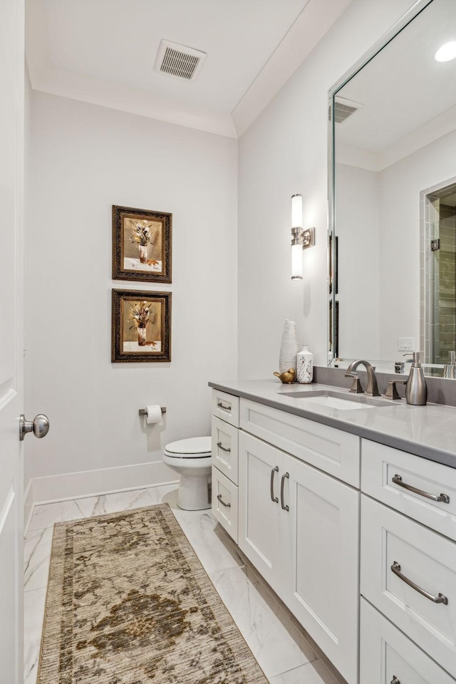 bathroom featuring toilet, ornamental molding, and vanity