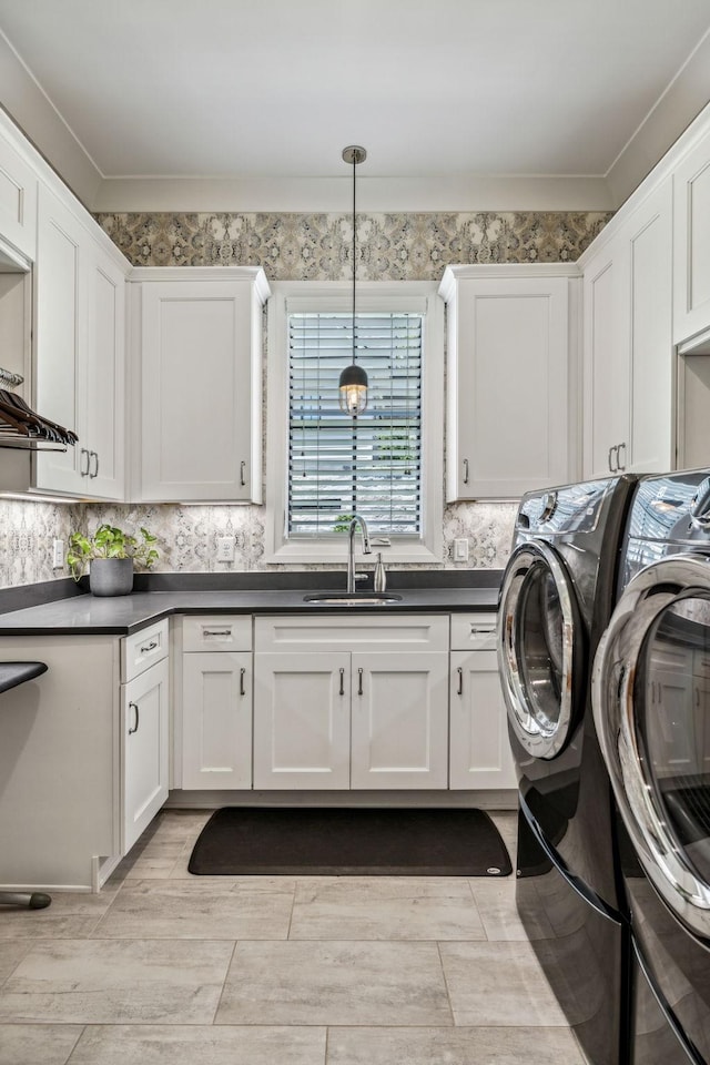 laundry room featuring cabinets, ornamental molding, washing machine and clothes dryer, and sink