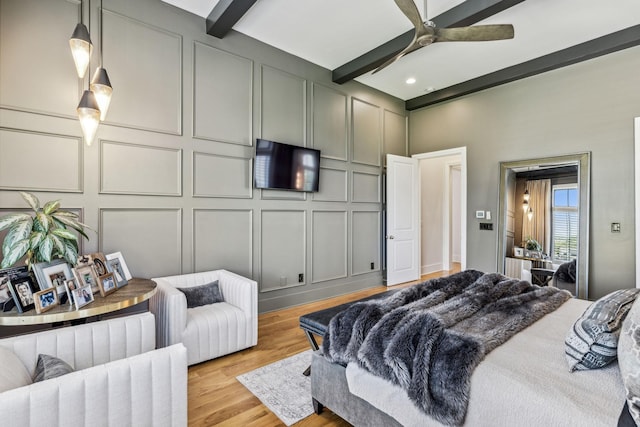 bedroom with ceiling fan, light wood-type flooring, and beamed ceiling