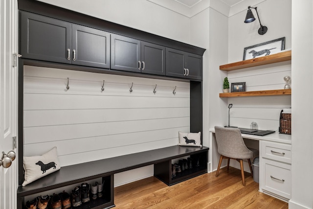 mudroom featuring built in desk and light hardwood / wood-style flooring