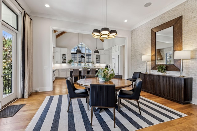 dining room featuring a wealth of natural light, brick wall, and light hardwood / wood-style flooring