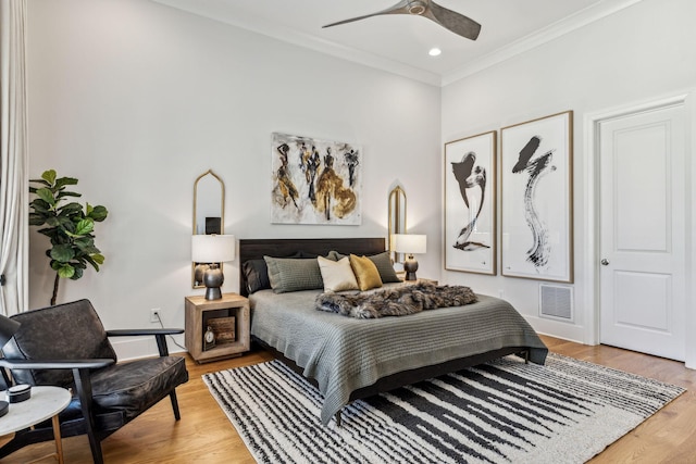 bedroom with ceiling fan, wood-type flooring, and crown molding