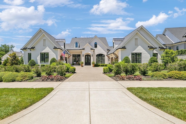 french provincial home with a front yard