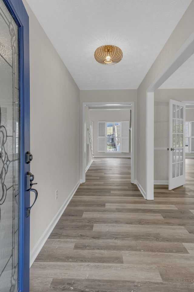 foyer entrance featuring a textured ceiling and light hardwood / wood-style flooring