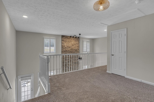 hallway featuring a textured ceiling and carpet flooring