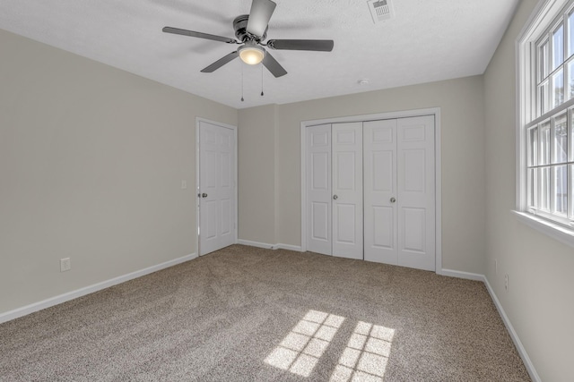 unfurnished bedroom with ceiling fan, a closet, and carpet floors