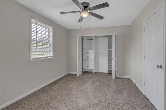 unfurnished bedroom featuring ceiling fan, a closet, a textured ceiling, and carpet flooring