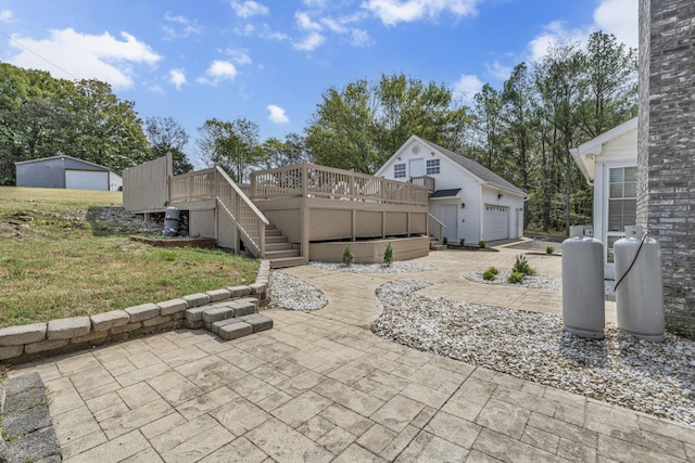 view of patio / terrace featuring an outbuilding, a wooden deck, and a garage