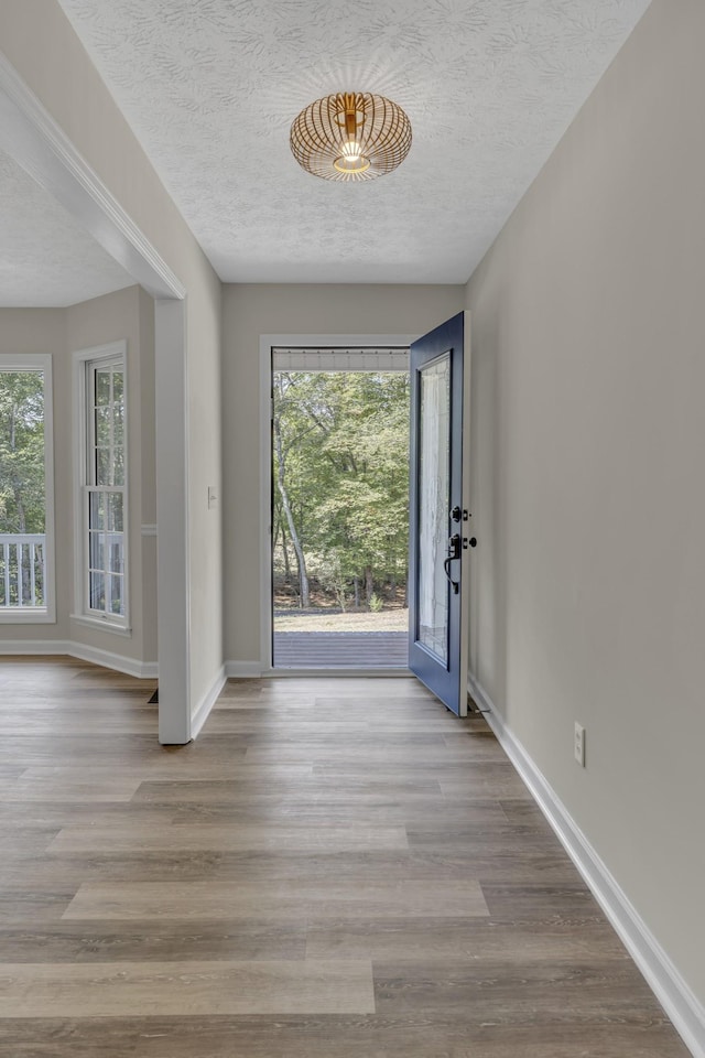 entryway featuring light wood-type flooring and a textured ceiling