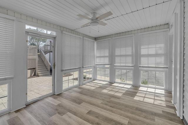 unfurnished sunroom with ceiling fan and a healthy amount of sunlight