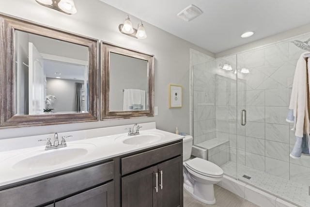 bathroom with toilet, vanity, tile patterned flooring, and a shower with door