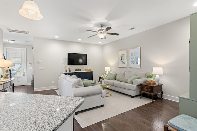 living room with dark wood-type flooring and ceiling fan