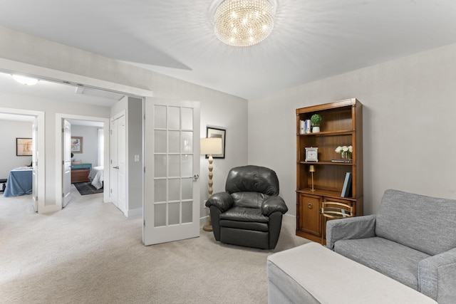 living area featuring light carpet and a notable chandelier