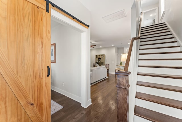 stairs with a barn door and wood-type flooring