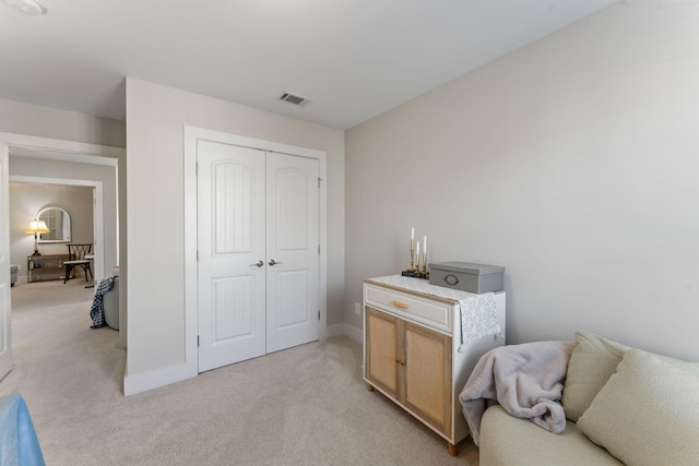 bedroom featuring light carpet and a closet