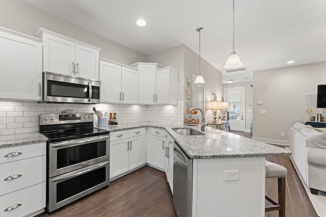 kitchen with sink, pendant lighting, white cabinets, and stainless steel appliances