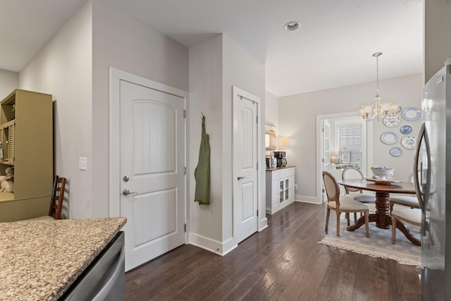 kitchen featuring an inviting chandelier, decorative light fixtures, dark hardwood / wood-style floors, and stainless steel refrigerator