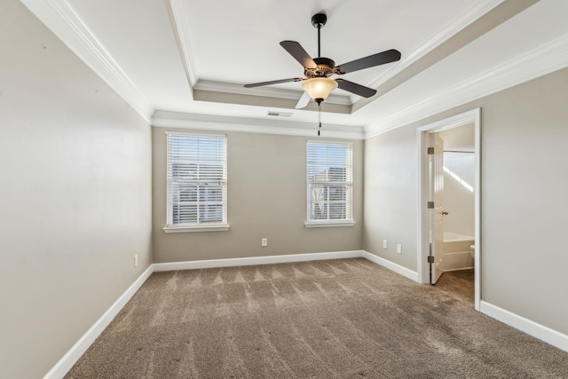 unfurnished room with crown molding, carpet, a healthy amount of sunlight, and a tray ceiling