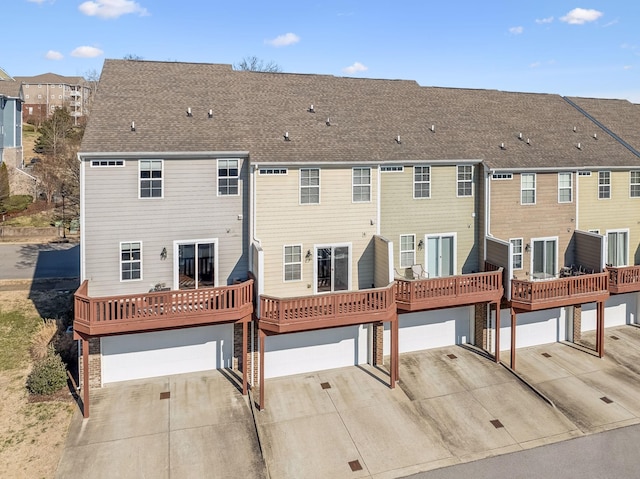 back of property featuring a garage and a deck