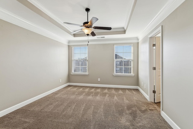 empty room with crown molding, carpet, plenty of natural light, and a tray ceiling