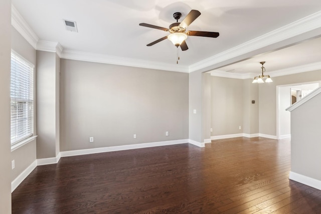 empty room with dark wood-type flooring, ceiling fan with notable chandelier, and ornamental molding