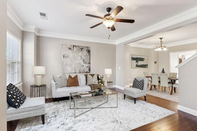 living room featuring ceiling fan with notable chandelier, hardwood / wood-style floors, and ornamental molding