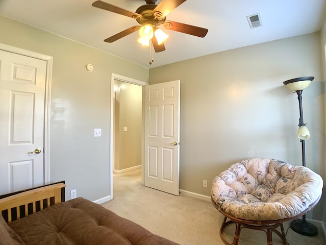 living area with ceiling fan and light carpet