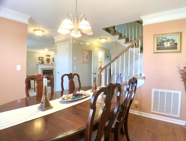 dining area with an inviting chandelier, ornamental molding, and wood-type flooring