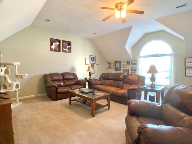 living room featuring ceiling fan, a textured ceiling, light carpet, and vaulted ceiling