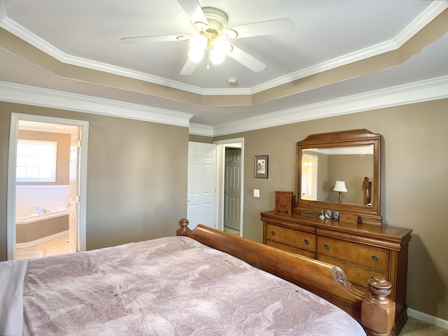 bedroom with ceiling fan, ensuite bath, a raised ceiling, and crown molding