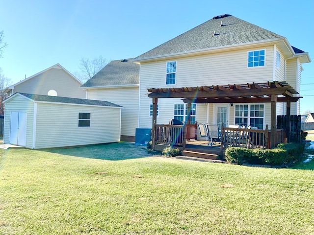 back of property featuring a wooden deck, an outbuilding, a yard, and a pergola