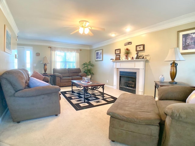 living room featuring ceiling fan, carpet, a tile fireplace, and crown molding