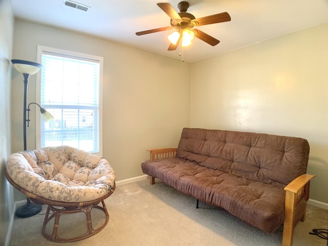 living area featuring light carpet and ceiling fan