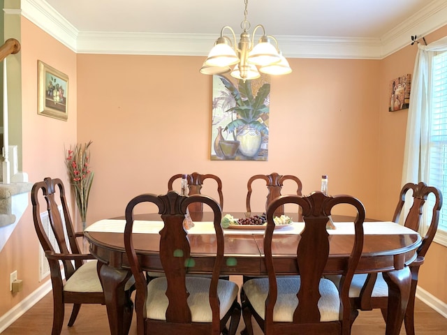 dining area featuring crown molding, wood-type flooring, and an inviting chandelier